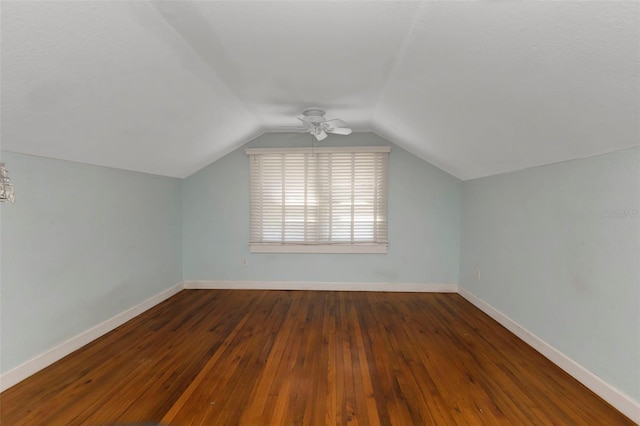 additional living space with lofted ceiling, a ceiling fan, baseboards, and dark wood-style flooring