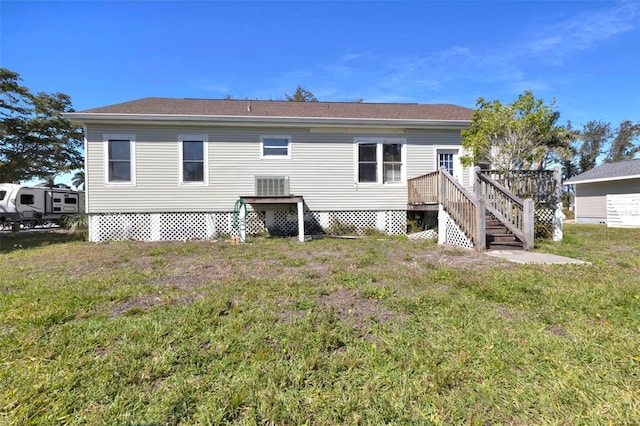 back of house featuring a deck and a lawn