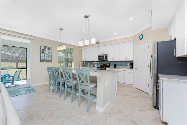 kitchen with tasteful backsplash, white cabinets, appliances with stainless steel finishes, and ornamental molding