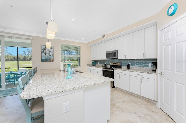 kitchen with a sink, decorative backsplash, white cabinets, appliances with stainless steel finishes, and crown molding