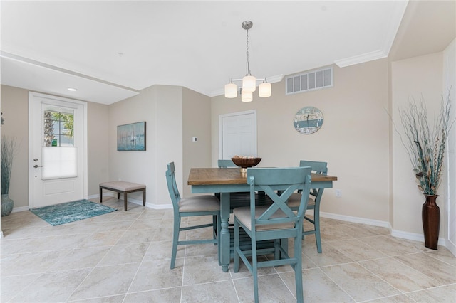 dining area with light tile patterned flooring, visible vents, crown molding, and baseboards