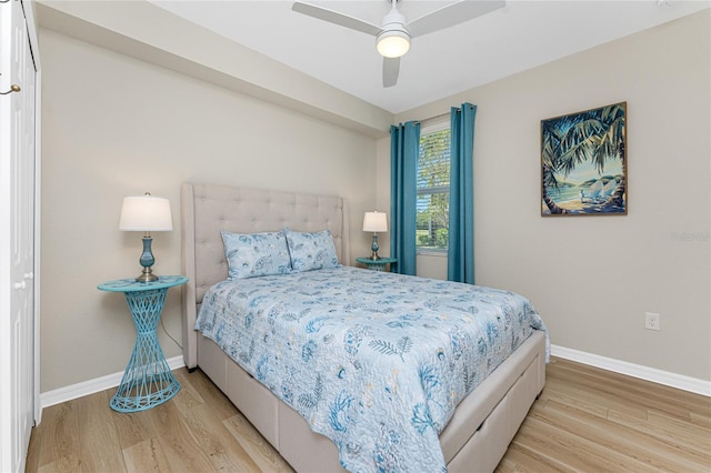 bedroom with light wood-style floors, baseboards, and ceiling fan