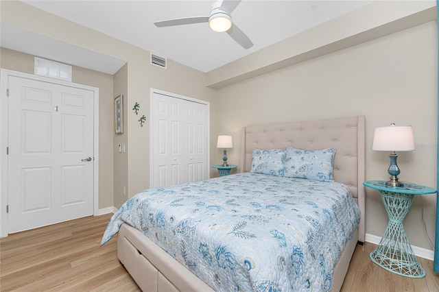 bedroom featuring visible vents, a ceiling fan, wood finished floors, a closet, and baseboards