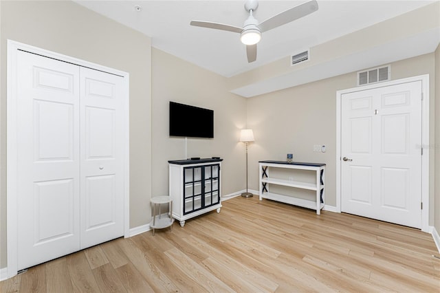 interior space featuring light wood-style flooring, baseboards, visible vents, and ceiling fan