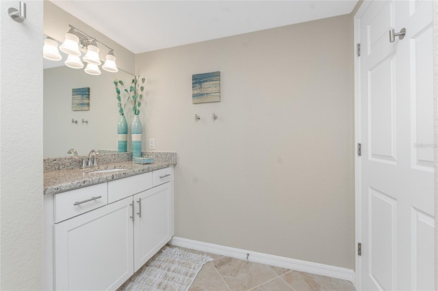 bathroom with vanity, baseboards, and tile patterned flooring