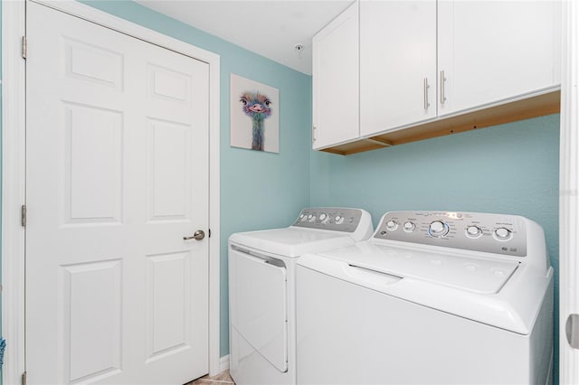 washroom with cabinet space and washer and clothes dryer