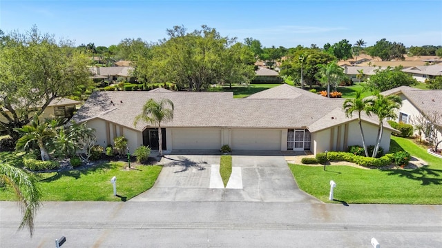 view of front of home featuring an attached garage, a front lawn, concrete driveway, and stucco siding