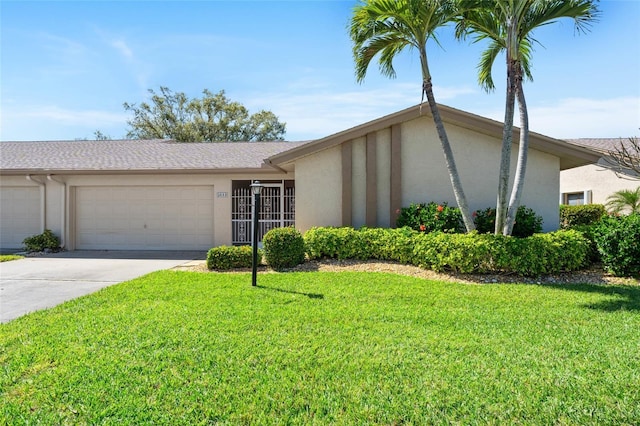 view of front of house featuring an attached garage, a front yard, concrete driveway, and stucco siding