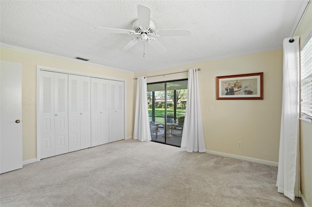 unfurnished bedroom featuring access to exterior, a textured ceiling, and crown molding