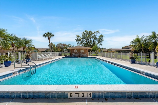 pool with a patio area and fence