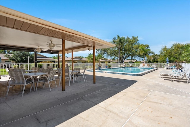 community pool featuring fence, a ceiling fan, and a patio