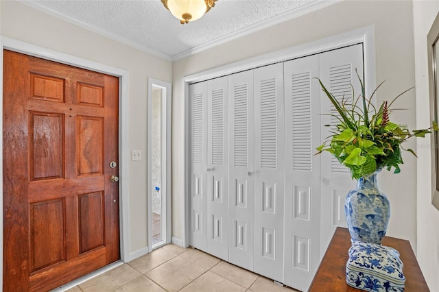 entrance foyer featuring ornamental molding, light tile patterned flooring, and a textured ceiling