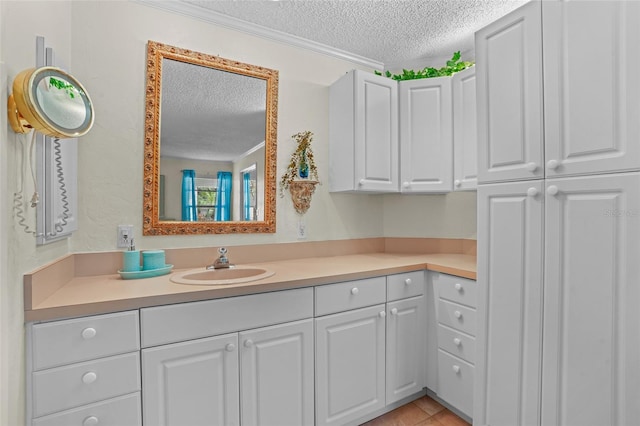 bathroom with tile patterned floors, crown molding, a textured ceiling, and vanity