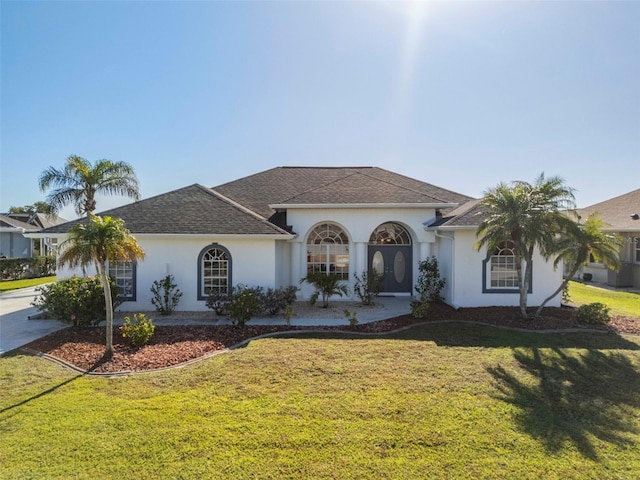 view of front of home featuring stucco siding, concrete driveway, and a front yard