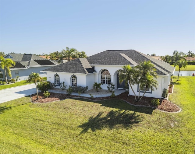 view of front of house with a shingled roof, a front lawn, driveway, and stucco siding