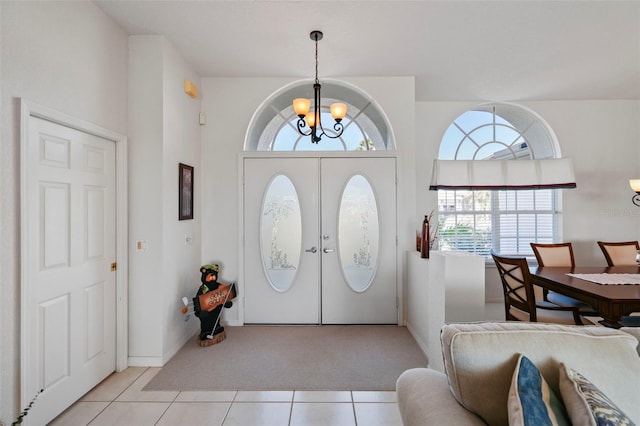 carpeted entryway featuring tile patterned flooring and a notable chandelier