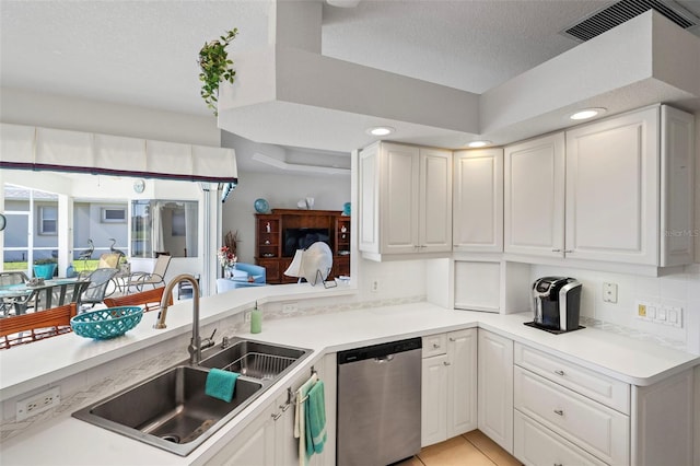 kitchen featuring tasteful backsplash, dishwasher, white cabinetry, and a sink