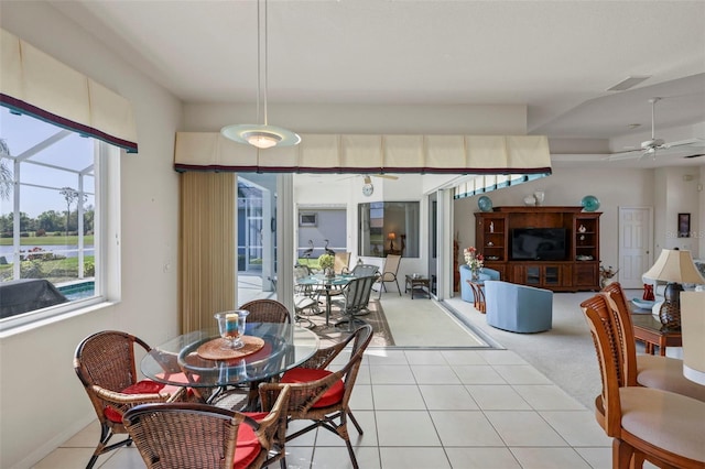 dining space featuring light tile patterned floors, visible vents, a ceiling fan, and a sunroom