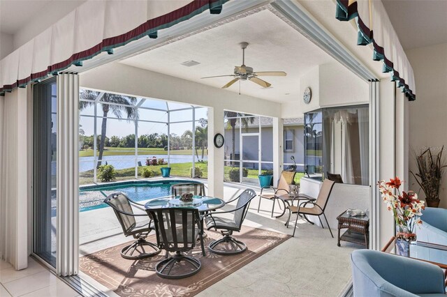 sunroom featuring a water view and ceiling fan