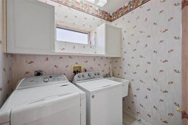 washroom with wallpapered walls, separate washer and dryer, cabinet space, and a sink