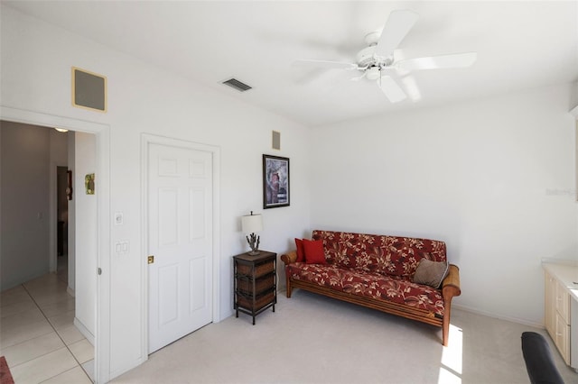 sitting room featuring light colored carpet, light tile patterned floors, a ceiling fan, and visible vents