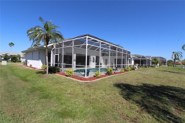 back of house featuring glass enclosure, a lawn, and an outdoor pool