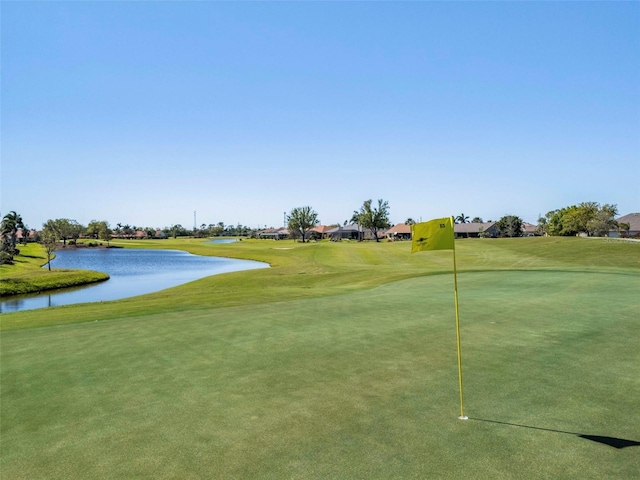 view of home's community with a yard, golf course view, and a water view