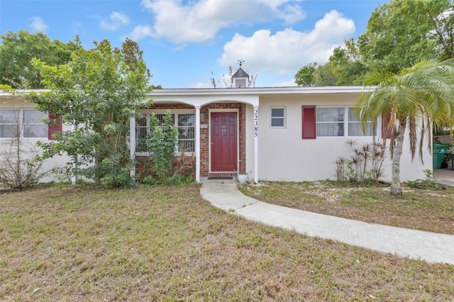 ranch-style house with stucco siding and a front lawn