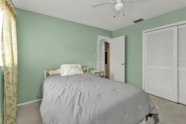 bedroom featuring visible vents, light carpet, a ceiling fan, a closet, and baseboards