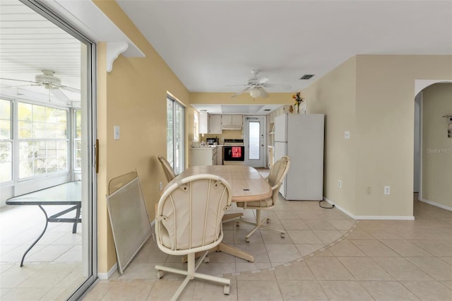 dining area featuring visible vents, arched walkways, light tile patterned flooring, and a ceiling fan