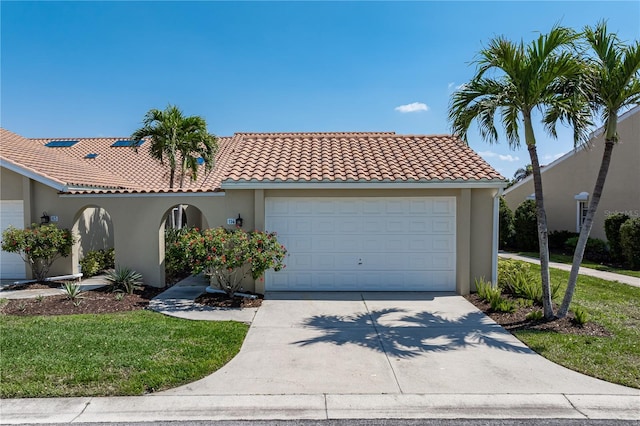 mediterranean / spanish-style home with a garage, driveway, a tiled roof, and stucco siding