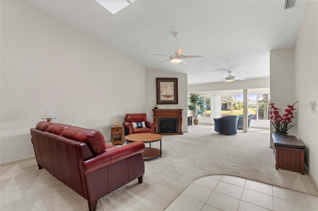 living room with light carpet, light tile patterned floors, visible vents, vaulted ceiling, and a fireplace