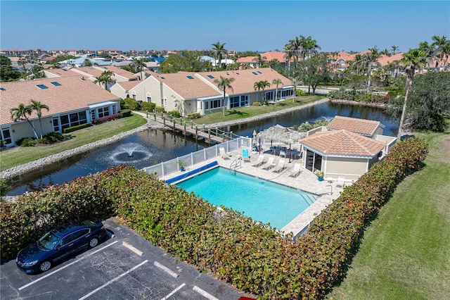 pool featuring a water view, a fenced backyard, a residential view, and a patio