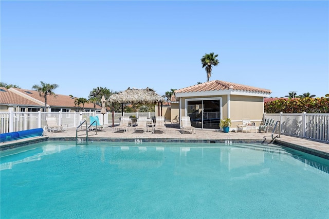 community pool with fence and a patio