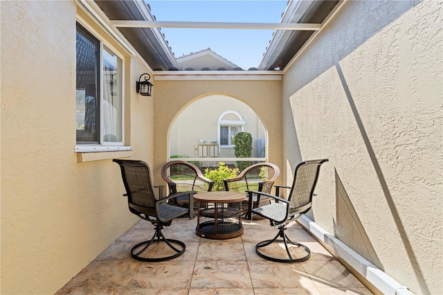 view of patio / terrace featuring glass enclosure