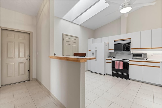 kitchen featuring a skylight, white refrigerator with ice dispenser, a toaster, range with electric stovetop, and light countertops