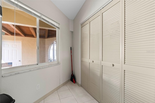 hallway featuring light tile patterned floors and baseboards