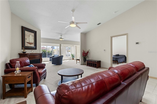 living room with lofted ceiling, light colored carpet, visible vents, ceiling fan, and baseboards