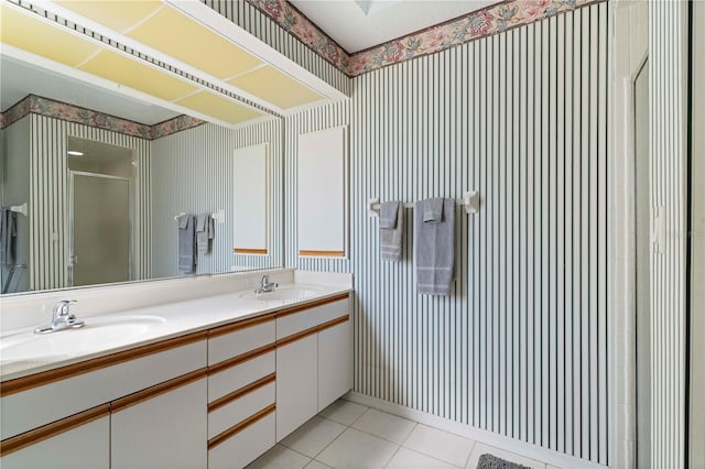 bathroom featuring a stall shower, tile patterned flooring, a sink, and wallpapered walls