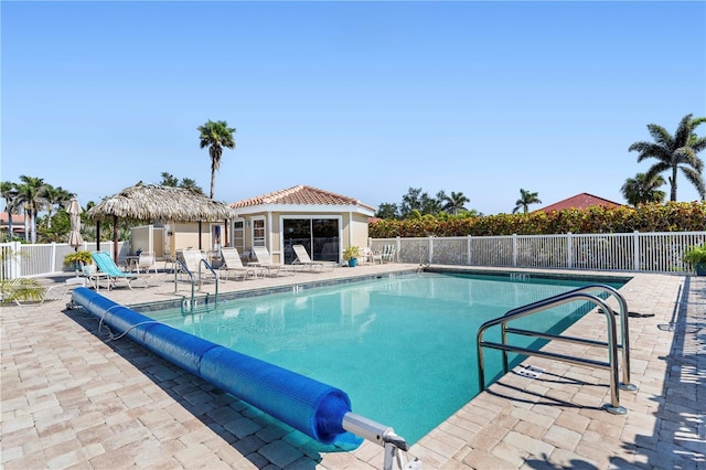 community pool with fence and a patio