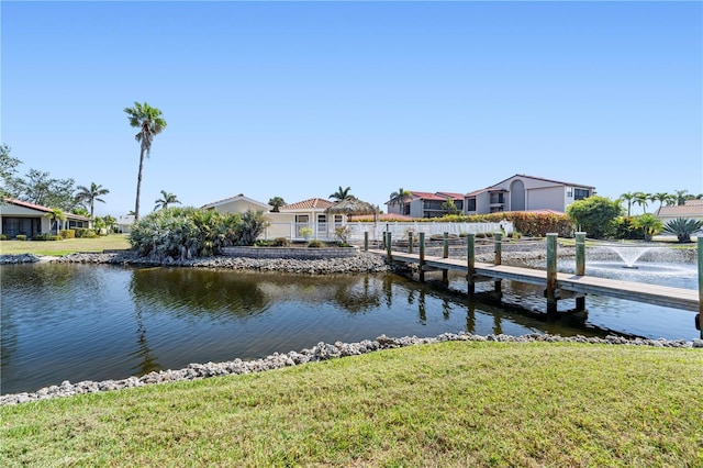 view of dock with a lawn and a water view