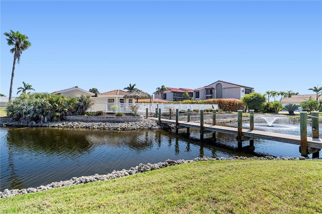 view of dock with a water view and a lawn