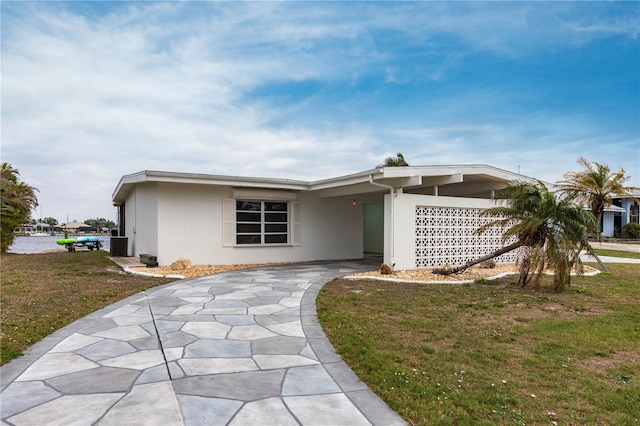 mid-century modern home with stucco siding and a front lawn