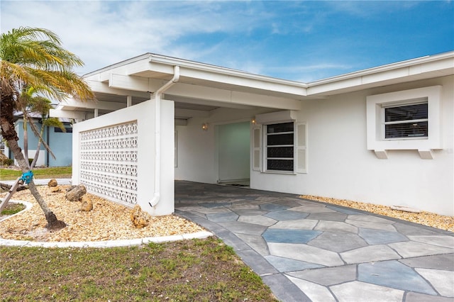 view of exterior entry with stucco siding