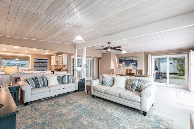 living area with tile patterned floors, wood ceiling, and ceiling fan