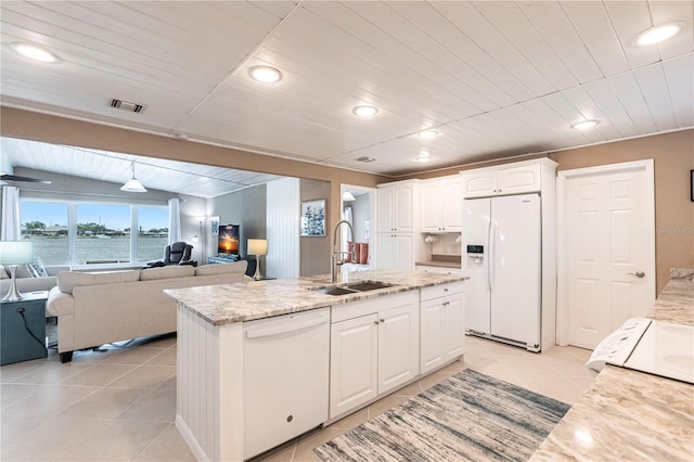 kitchen featuring a center island with sink, light tile patterned flooring, white appliances, white cabinetry, and a sink