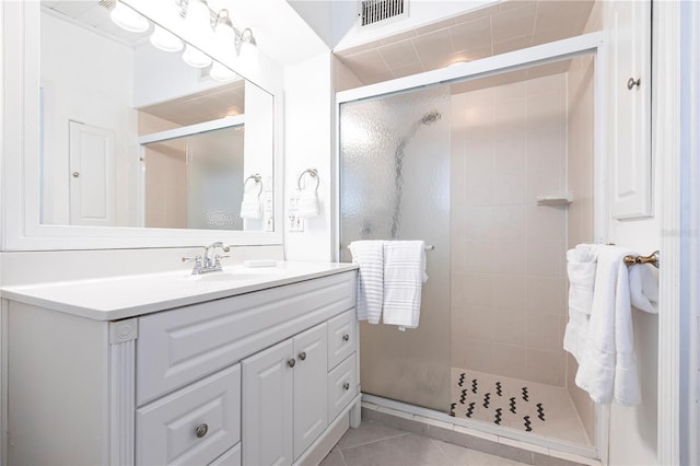 full bathroom featuring visible vents, vanity, a shower stall, and tile patterned flooring