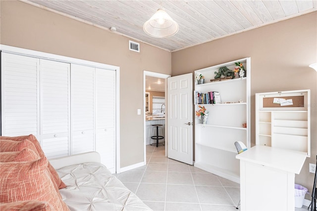 bedroom with light tile patterned floors, baseboards, visible vents, a closet, and wooden ceiling