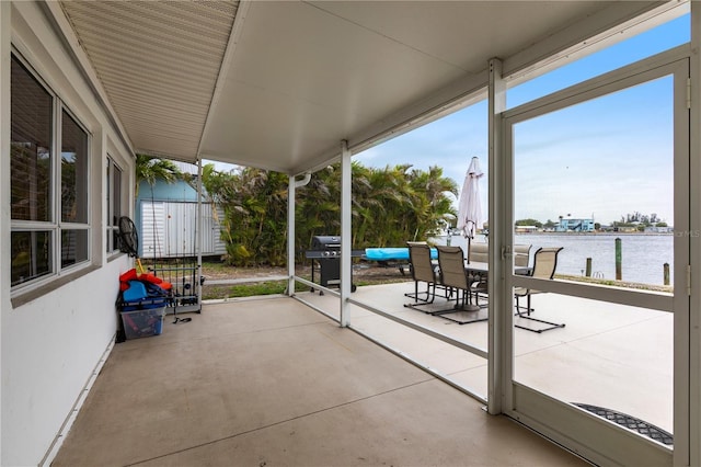 view of patio with outdoor dining space, a water view, and area for grilling