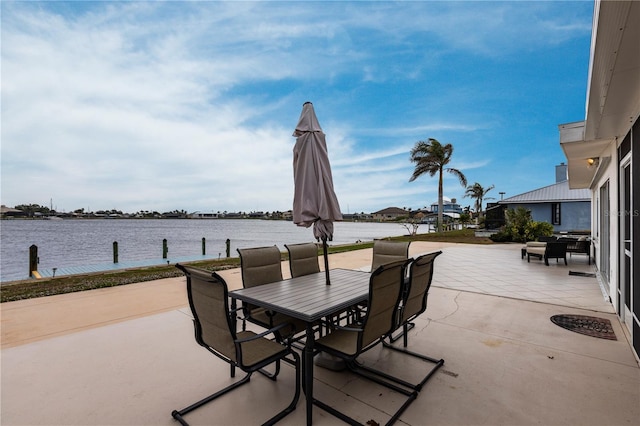 view of patio with outdoor dining area and a water view